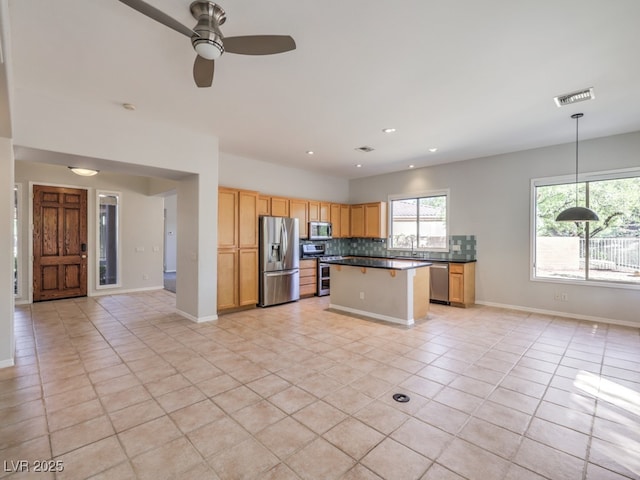 kitchen with light tile patterned flooring, appliances with stainless steel finishes, and plenty of natural light