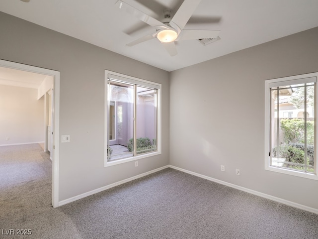 carpeted spare room featuring ceiling fan