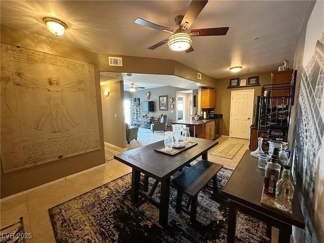 tiled dining space featuring ceiling fan