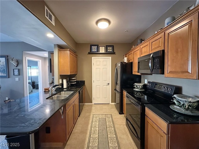 kitchen with light tile patterned flooring, sink, dark stone counters, and black appliances