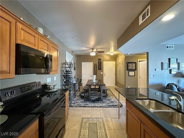 kitchen featuring light tile patterned flooring, ceiling fan, black range with electric stovetop, and sink