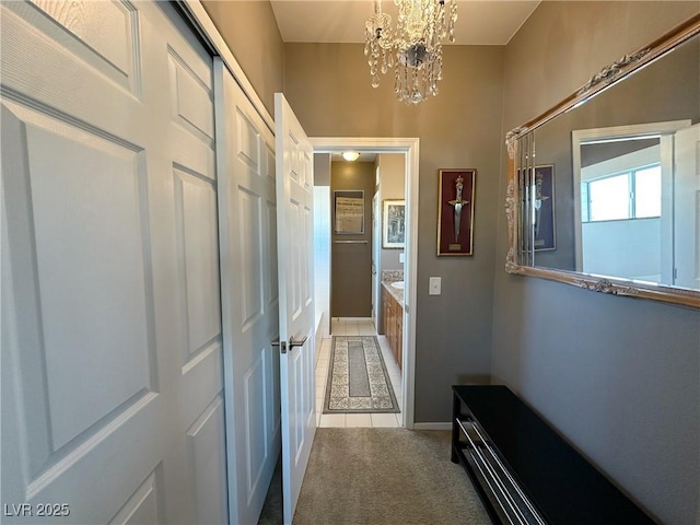 corridor featuring carpet floors and a notable chandelier