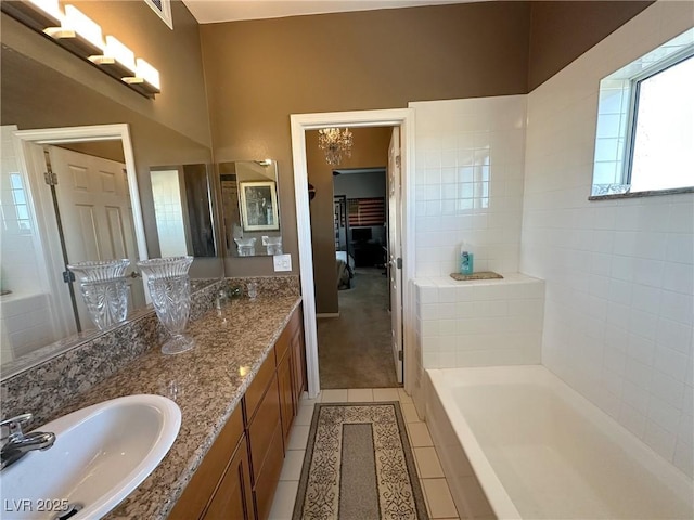 bathroom with vanity, a tub, and tile patterned floors