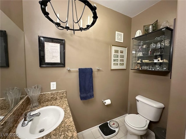 bathroom featuring vanity, toilet, tile patterned flooring, and a notable chandelier