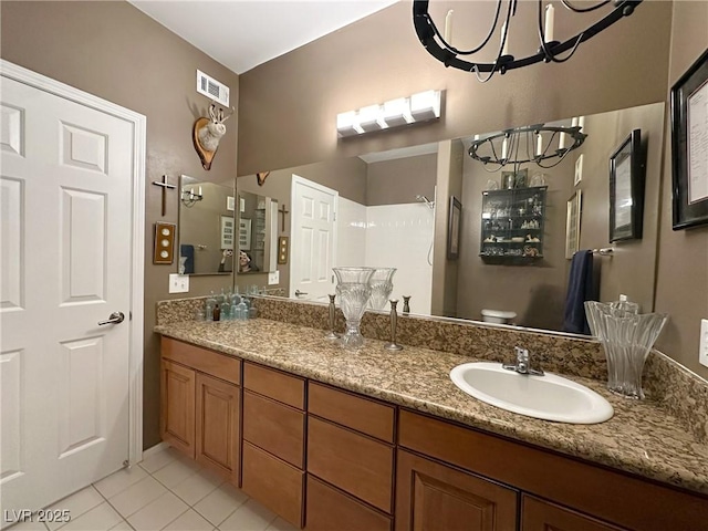 bathroom featuring vanity, toilet, tile patterned flooring, and a notable chandelier