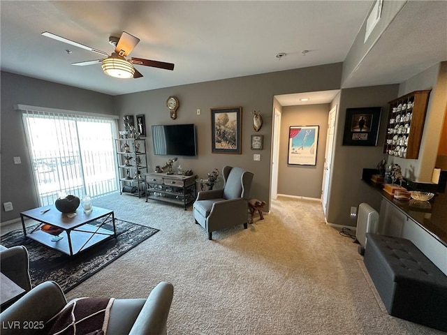 living room featuring bar, light colored carpet, and ceiling fan