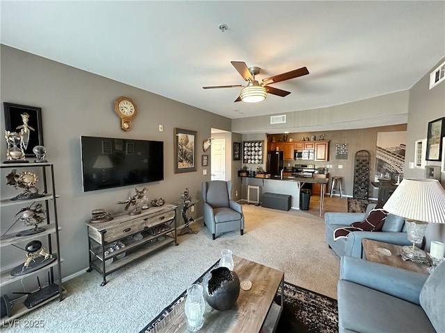 carpeted living room with ceiling fan