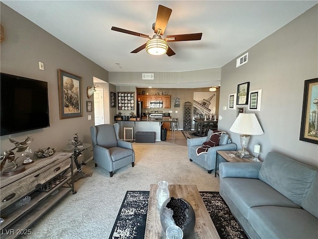 carpeted living room with ceiling fan