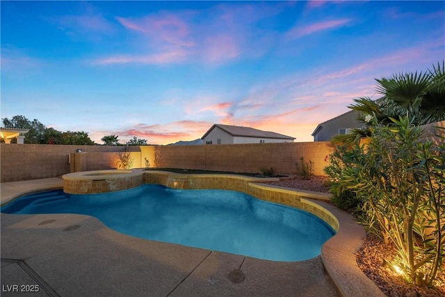 pool at dusk with an in ground hot tub and a patio area