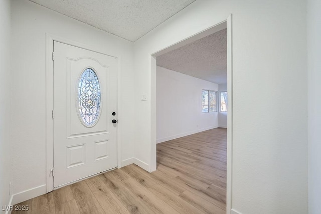 entrance foyer featuring light hardwood / wood-style floors and a textured ceiling