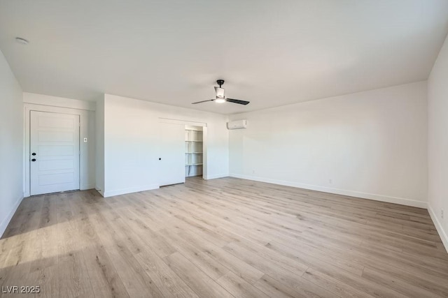 unfurnished bedroom featuring a wall mounted air conditioner, ceiling fan, and light wood-type flooring