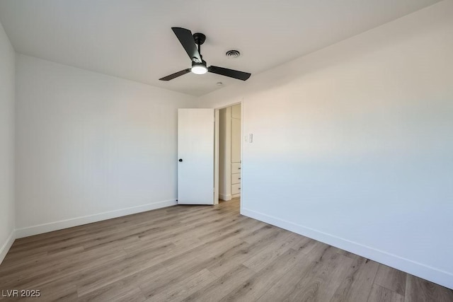 empty room with ceiling fan and light hardwood / wood-style floors