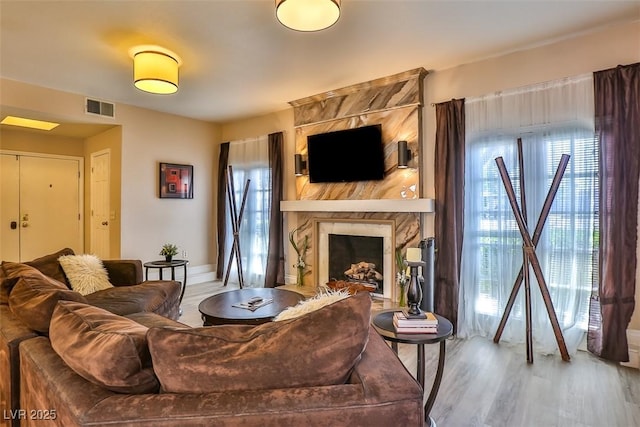 living room with a fireplace, wood-type flooring, and plenty of natural light