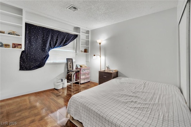 bedroom featuring hardwood / wood-style flooring and a textured ceiling