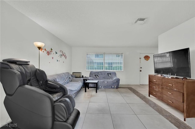 living room with a textured ceiling and light tile patterned flooring