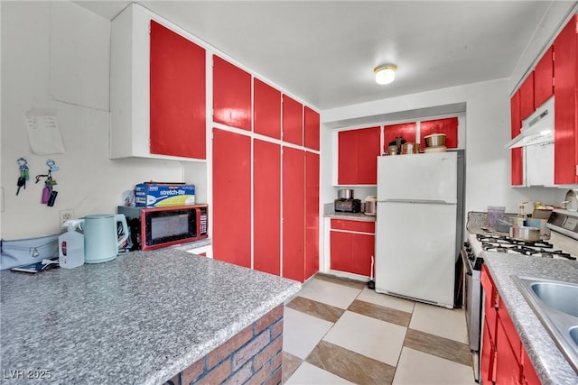 kitchen featuring sink, stainless steel range with gas cooktop, and white refrigerator