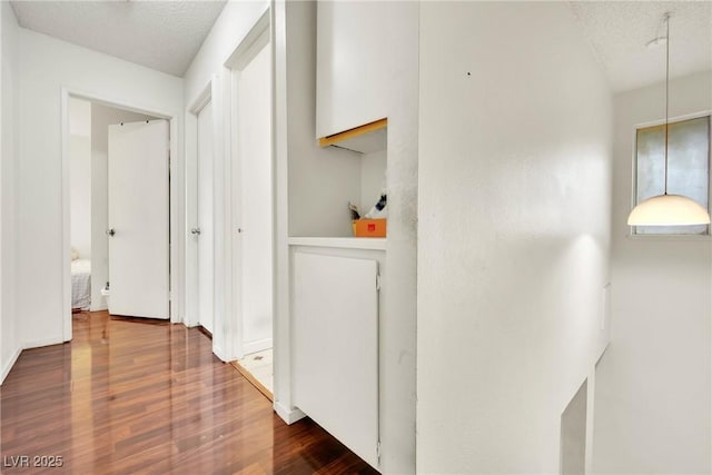 corridor featuring hardwood / wood-style floors and a textured ceiling