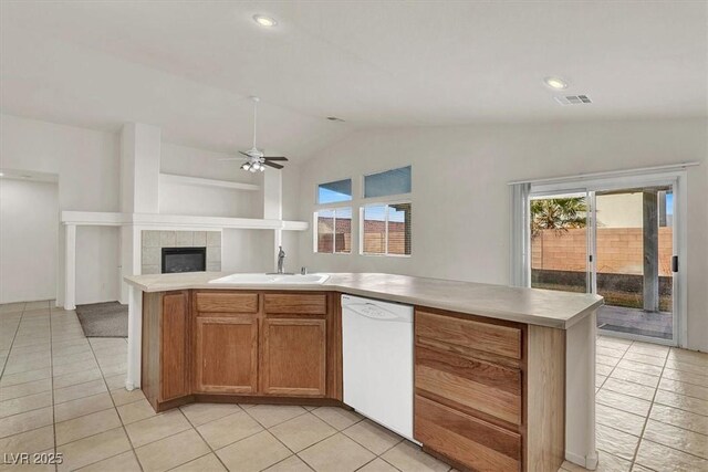 kitchen featuring white dishwasher, sink, light tile patterned floors, and vaulted ceiling