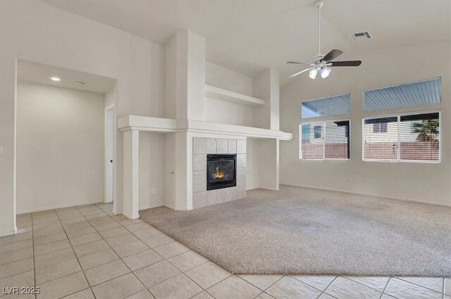 unfurnished living room featuring light tile patterned floors, built in features, a tile fireplace, and ceiling fan