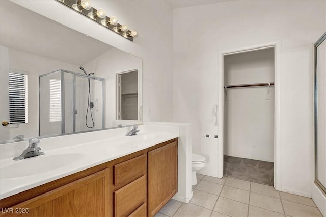 bathroom featuring an enclosed shower, vanity, tile patterned floors, and toilet