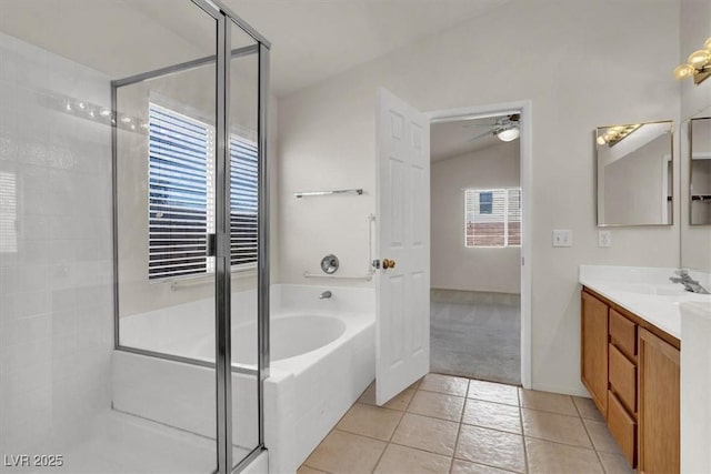 bathroom featuring shower with separate bathtub, lofted ceiling, vanity, ceiling fan, and tile patterned floors