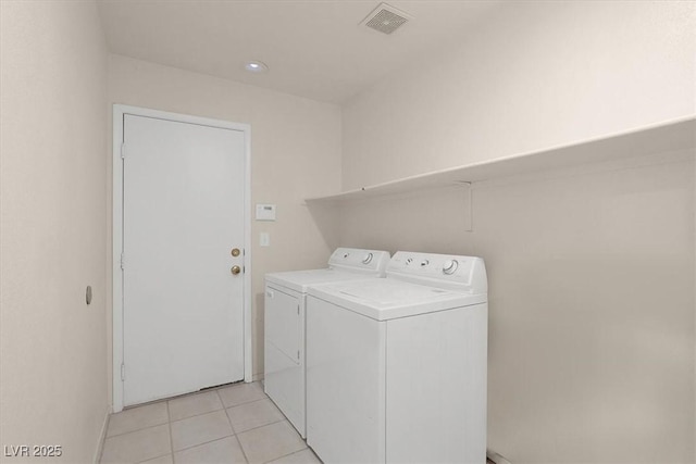 laundry room with washer and dryer and light tile patterned flooring