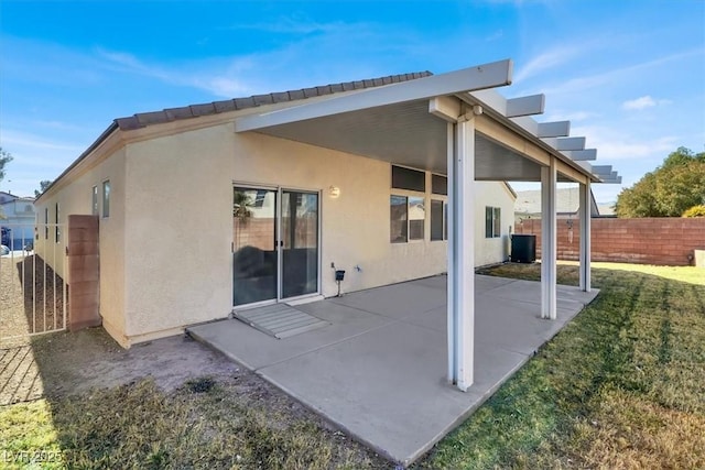 rear view of property featuring a lawn and a patio area