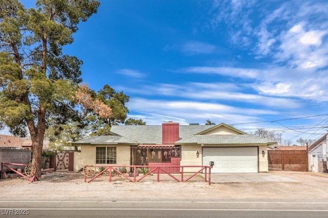 ranch-style house featuring a garage, driveway, a fenced front yard, and stucco siding