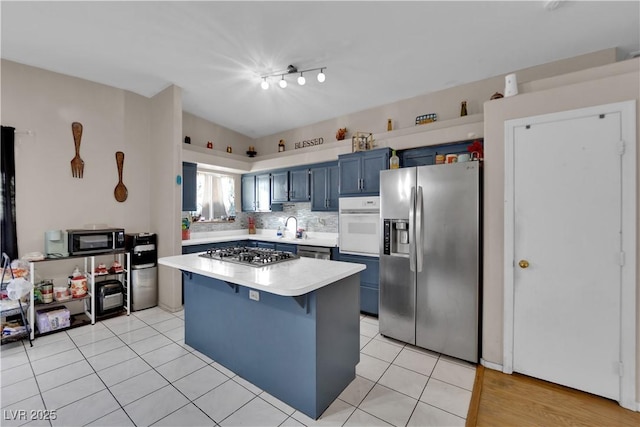 kitchen with light tile patterned flooring, sink, a breakfast bar area, stainless steel appliances, and blue cabinetry