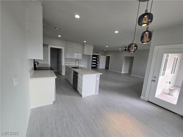 kitchen with pendant lighting, sink, dishwasher, range, and white cabinets