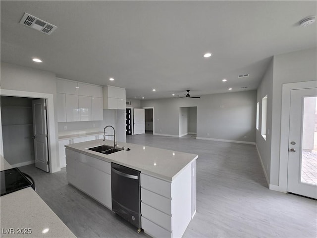 kitchen featuring sink, range, black dishwasher, an island with sink, and white cabinets