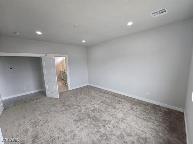 unfurnished bedroom with ensuite bath and carpet flooring