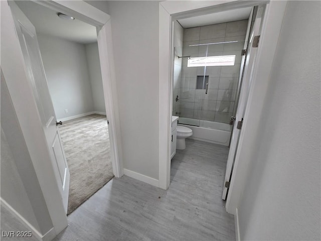 full bathroom featuring tiled shower / bath, wood-type flooring, toilet, and vanity