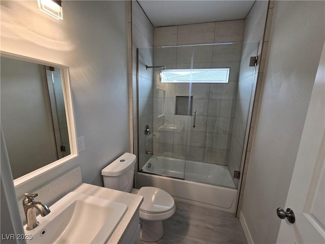 full bathroom with vanity, hardwood / wood-style flooring, enclosed tub / shower combo, and toilet