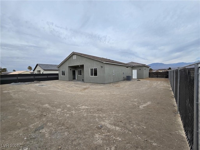 rear view of house featuring central AC unit and a mountain view