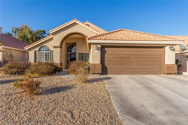 view of front of house with an attached garage, a tiled roof, concrete driveway, and stucco siding