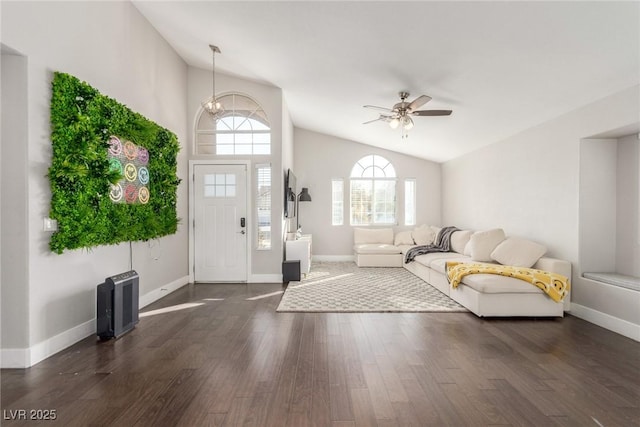 entrance foyer with dark wood-style flooring, vaulted ceiling, baseboards, and ceiling fan with notable chandelier