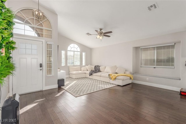 unfurnished living room featuring baseboards, visible vents, dark wood finished floors, vaulted ceiling, and ceiling fan with notable chandelier