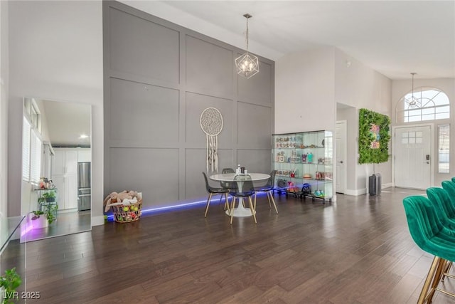 interior space with dark hardwood / wood-style flooring, a chandelier, and a high ceiling