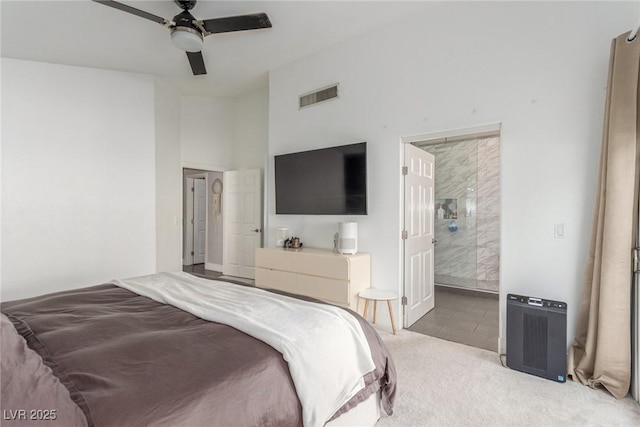 carpeted bedroom featuring ceiling fan, ensuite bath, and lofted ceiling