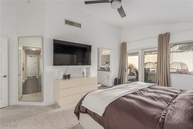 bedroom featuring ensuite bathroom, lofted ceiling, access to exterior, ceiling fan, and light carpet