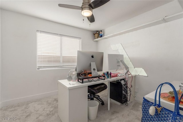 carpeted office space with ceiling fan and baseboards