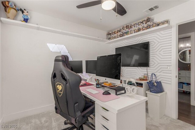 carpeted office space featuring ceiling fan