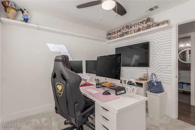 office area with light colored carpet, visible vents, ceiling fan, and baseboards