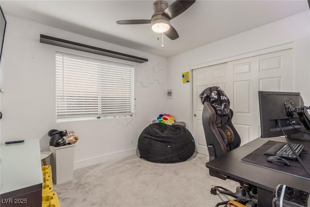 carpeted office featuring a ceiling fan and baseboards