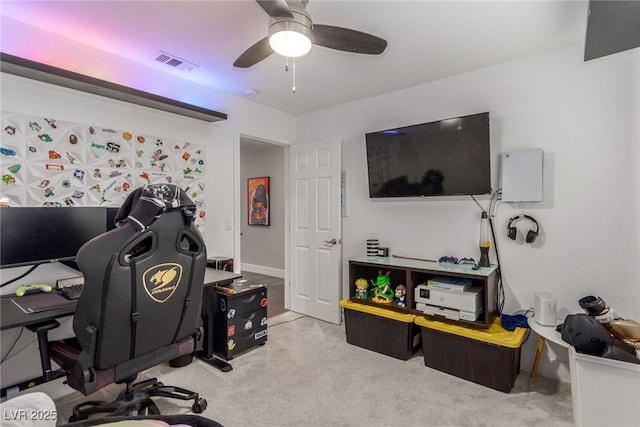 carpeted home office featuring a ceiling fan and visible vents