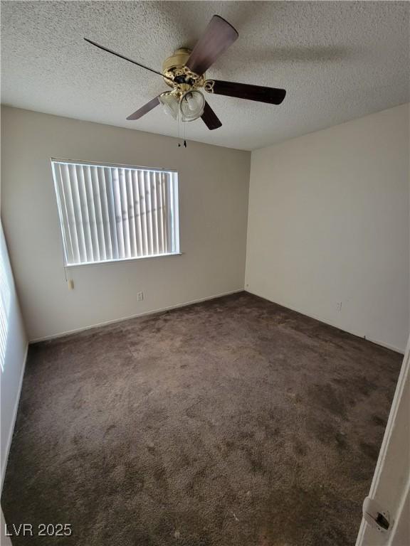 carpeted spare room with ceiling fan and a textured ceiling