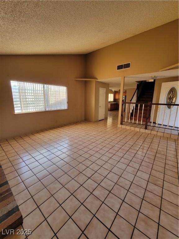 empty room featuring light tile patterned floors and a textured ceiling