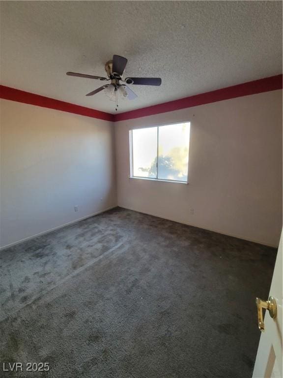 carpeted empty room featuring ceiling fan and a textured ceiling