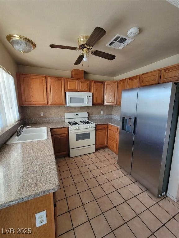 kitchen with light tile patterned floors, sink, white appliances, ceiling fan, and decorative backsplash